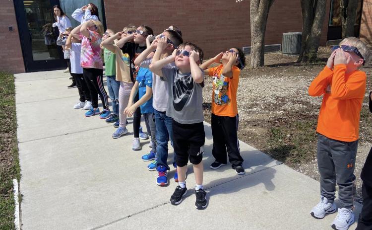 Above: Students at Jeffrey Elementary in Osceola take in the eclipse on Monday while wearing glasses. The last eclipse was 2017 so these kids aren’t old enough to remember it. Below: One activity was learning eclipse stages with Oreos.