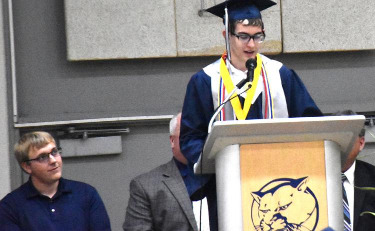 Above: Colton Duncan gives the valedictorian speech while former math teacher and speaker Andrew Steskal watches. Below: Matthew Frazier and Nathaniel Avers walk out hand-inhand with their diplomas after graduating. PCN photos by Beth Sparrow.