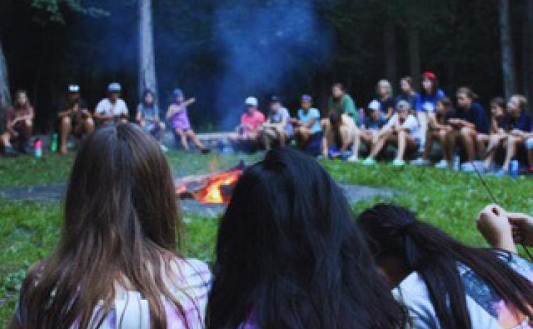 Campers gather round the campfire as they hear the gospel message. Photo provided.