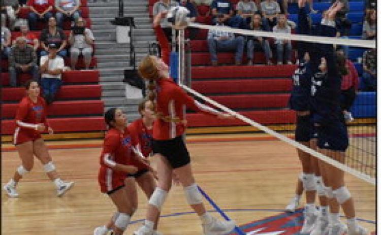 Peyton Hofmann goes up for a kill against Cross County’s block with her teammates’ support. PCN photo by Beth Sparrow.