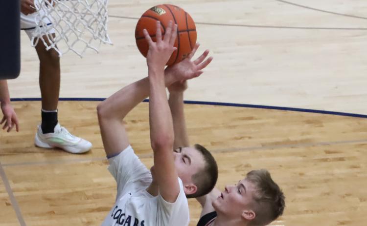 Cross County junior Benson Seim (33) grabs the offensive rebound and draws the foul on the Cozad player. Seim led CC with 19 points, but the Cougars dug to deep a hole in the first half and lost to the Haymakers 53-50. PCN photos by Ken Kush.