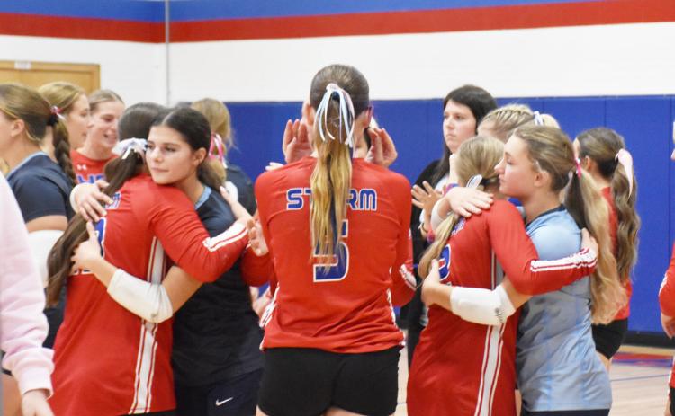Thursday’s volleyball game was preceded by an announcement and followed with prayer, hugs and flowers from Nebraska Christian. Left: Nebraska Christian girls hug the High Plains team members. Right: Erin and Chad Ackerson (Payton’s parents) receive hugs from the team. Below: A chair was left with Payton’s uniform in memorial between Assistant Coach Pinneo and Taya Hans. PCN photos by Beth Sparrow.