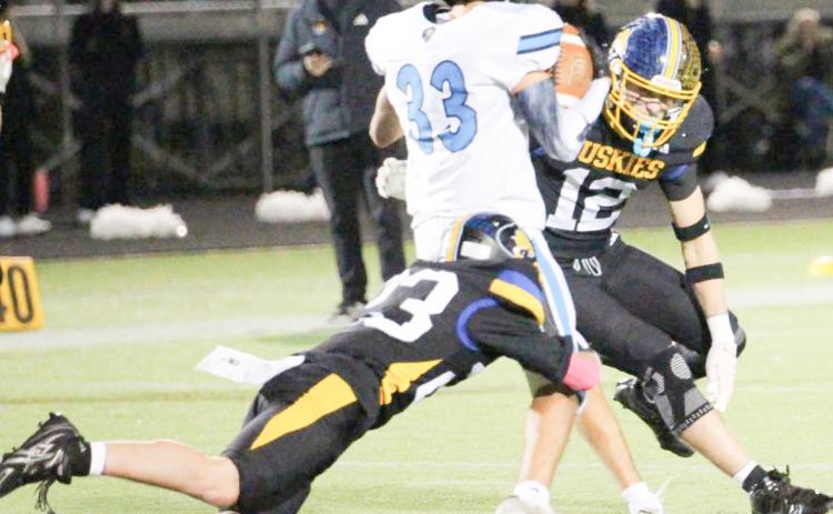 Shelby-RC senior Jett Vrbka (12) and a teammate combine to make the stop on the Omaha Christian ball carrier. PCN photo by Travis Lane.