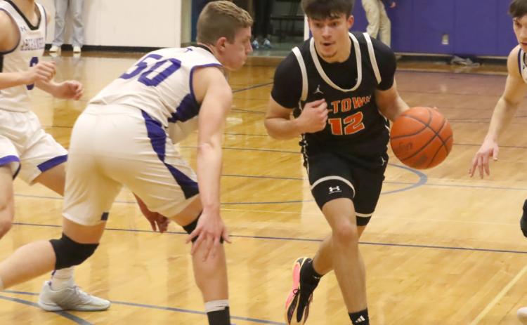 Junior Jackson Winslow (12) tries to get around the defense of Archangels Catholic’s Gage Braun. Winslow led the Bulldogs with 18 points, but it was not enough as Archangels Catholic Defenders defeated Osceola 65-42. PCN photo by Ken Kush.