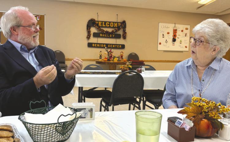 Above: Ryan Southan with the attorney general’s office talks with Patty Teig in Shelby about scams. PCN photo by Beth Sparrow. Below: A group of about 27 came to Polk to hear him speak on the same topic. Photo provided.