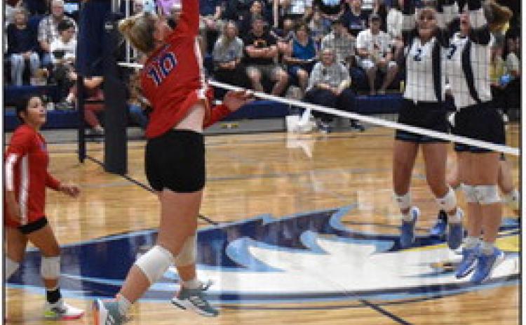 Courtney Carlstrom goes up for a kill against Nebraska Christian’s block with Gahvi Lesiak watching. PCN photo by Beth Sparrow.