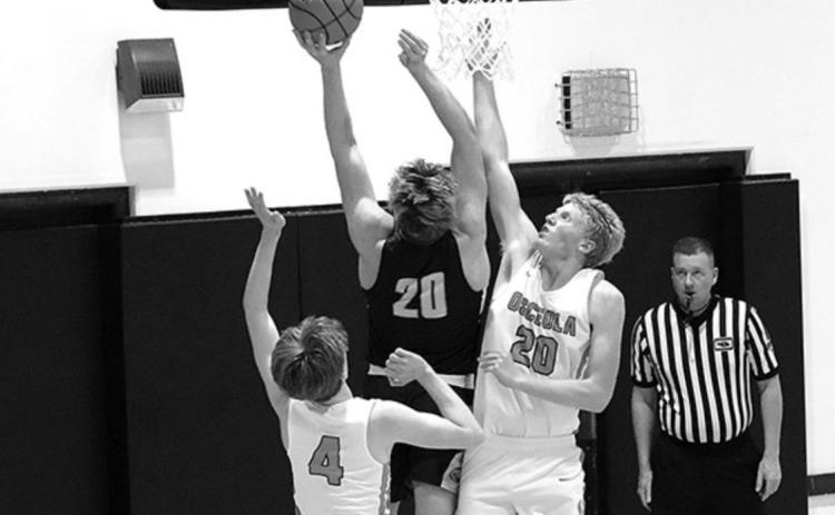 Cougar Cory Hollinger tries to get the ball in past the arms of Wyatt Urban and Pierce Branting from Osceola. Photo by Angie Hild.