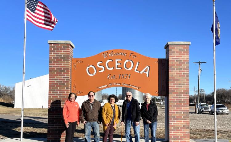 The Osceola sign now has flags. Pictured are Connie Boruch, John and Debbie Girard, and Norm and Marian Hofbauer. PCN photo by Lexi Reimers.