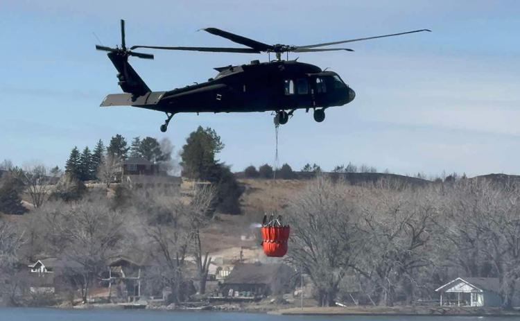 Above -A helicopter refills with water as efforts continue to contain the wildfires in western Nebraska. Top below- Wildfires rage on in Cottonwood area. Photo was provided.