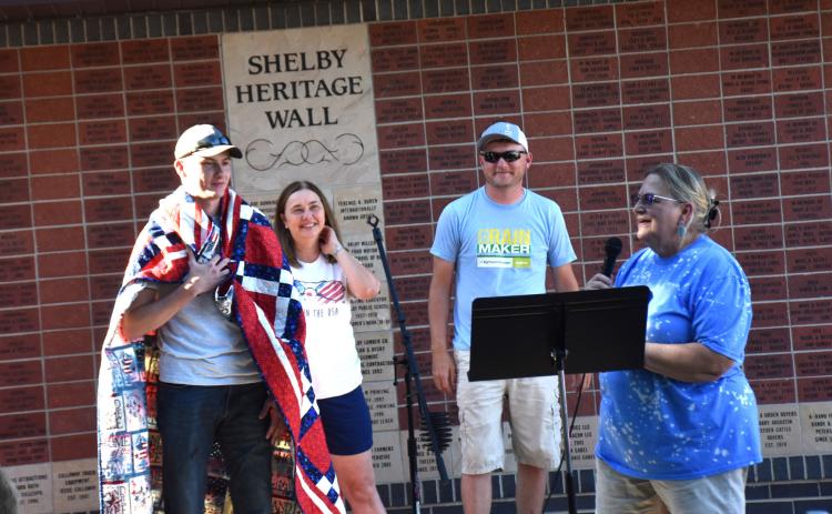 Dylan Rathman (left), a graduate of Shelby-Rising City High School, received a Quilt of Valor while on leave last week. Also pictured are his mom, his brother and Eileen Krumbach (QOV representative. PCN photo by Beth Sparrow.