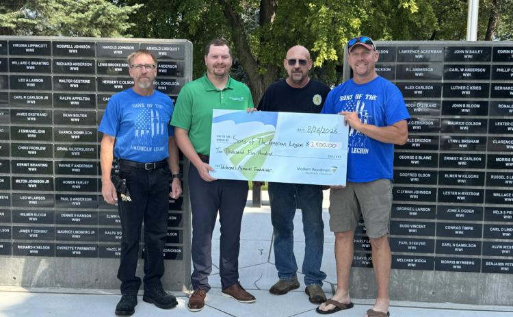 Aaron Giannou with Modern Woodmen matched funds of $2500 for the Sons of the Legion memorial wall. Here is Giannou presenting a check to some members. Photo provided.