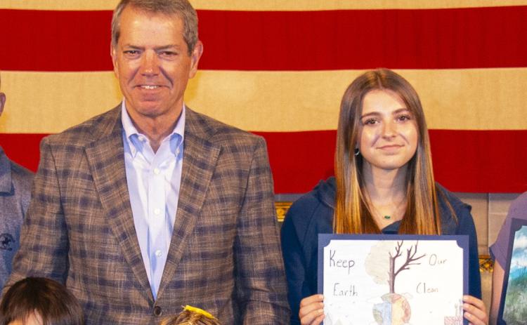 Ashtyn Quast, a seventh-grade student from High Plains Community Schools will have her art featured in the 2024 Nebraska environmental calendar. She is pictured here just to the right of Governor Pillen. Photo provided.