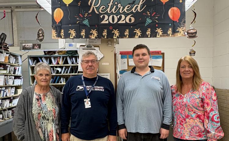 Bob Zelasney celebrates with his coworkers. Pictured are Sue, Bob Zelasney, Levi and Barb. Below: Zelasney sorts some mail before going on his route. PCN photos by Beth Sparrow.