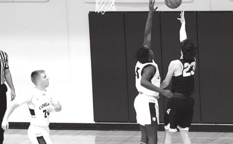 Cougar James Elgin defends against the shooter from Heartland in the subdistrict finals last week. Photo by Angie Hild.