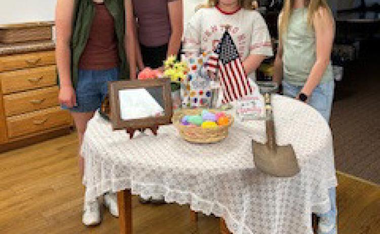 Left: Four girls helped set the military child’s table at a Legion Auxiliary meeting. Right: Poppy poster winners were 4th graders Zaara Moore and Scarlet Peterson. Posters were displayed at Economy Hometown Market. Photos provided.