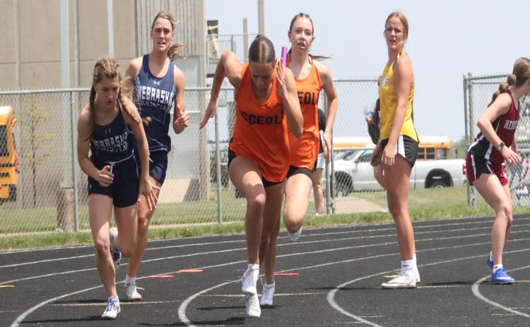 Osceola’s Camryn Peterson makes the exchange with Alexis Burritt in the 4x100 relay won by the Bulldogs. PCN Photo by Ken Kush