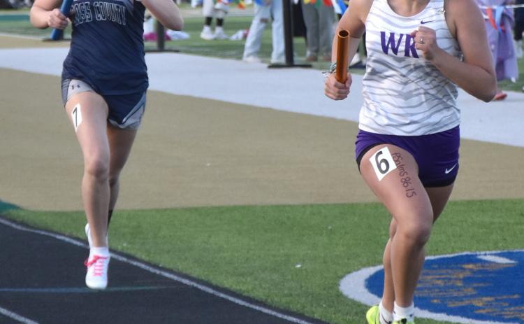 Above: Ella Clark runs her portion of the 4x400 just behind a Wood River girl. PCN file photo by Beth Sparrow.