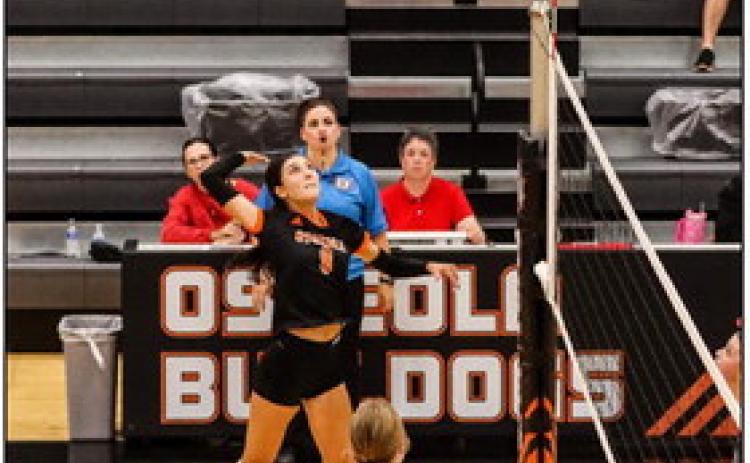 Above: Rori Wieseman goes up for the kill. Below: Taylin Sanley goes up against two Titan blockers. PCN photos by Blaine Winslow.