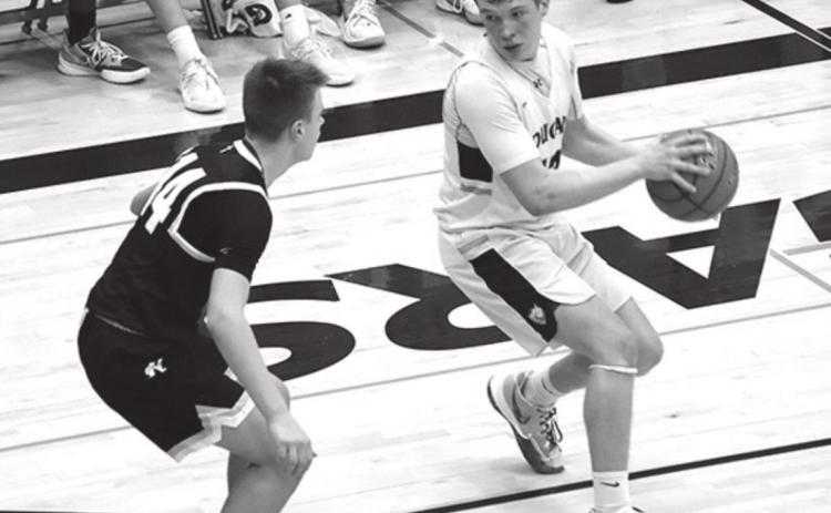 Cougar Senior Haiden Hild takes the ball down the court against a defender in subdistricts last week. Photo by Angie Hild.