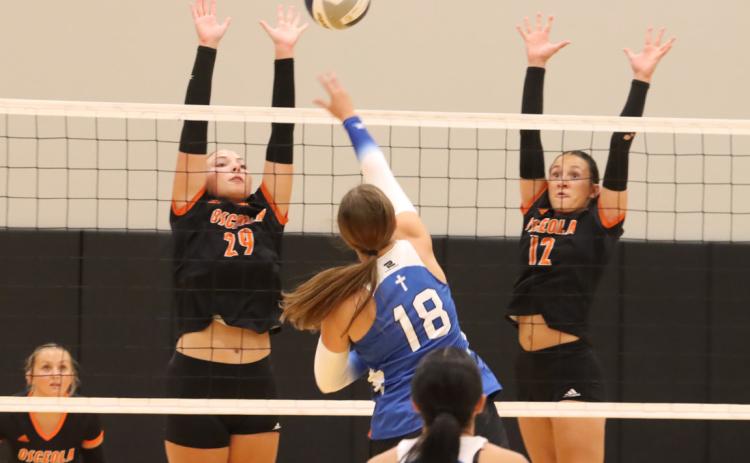 Above-Osceola’s Graci Conkling (29) and Alexis Burritt (12) combine to set up the block against the attack from an Archangels Catholic player earlier this year. Wins over Cedar Bluffs and Mead this past week has the Bulldogs humming along with a 5-0 record. Osceola clashed with Cross County on Tuesday night at the Cougars home triangular. PCN file photo by Ken Kush.