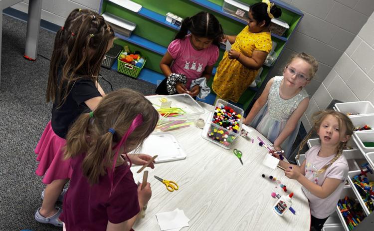 Above: HPC elementary students do some crafts in their last days. Below: HPC Kindergarten and First Grade visited the Lincoln Zoo last week. Here two boys sit in the O of Zoo while others are in front. Photos provided.