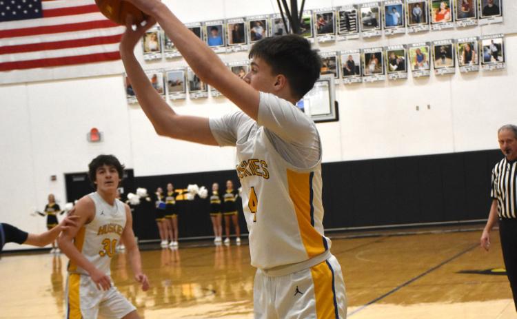Shelby-RC’s Jarren Kravig launches a baseline three-pointer in the Huskies win over NE. Christian. Kravig had 17 points in the win. PCN photo by Beth Sparrow.