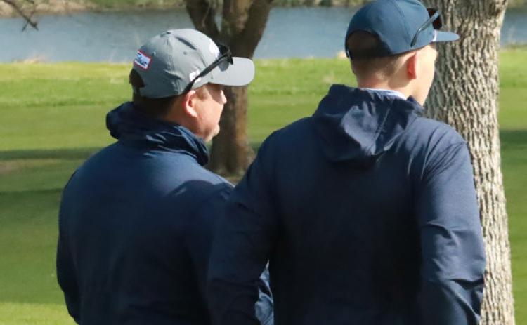 Cross County head coach Jimmy Blex (left) and Benson Seim (right) discuss Seim’s options off the No. 4 tee-box during last weekend at the David City Invite. Seim led the Cougars at North Bend with a round of 86. PCN file photo by Ken Kush.