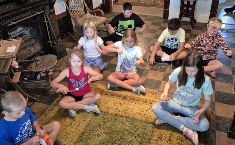 Above: Osceola fourth graders played with a homemade toy at the museum. PCN photo by Ken Kush.