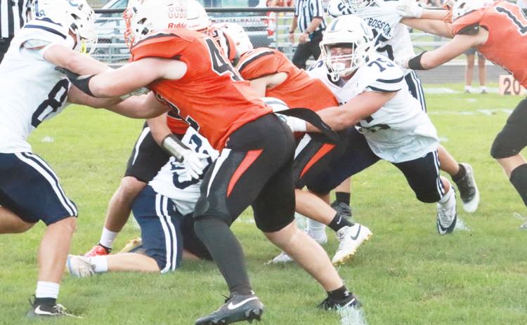 Top- Cross County senior Mason Quilhot (75) grabs the Stanton ball carrier