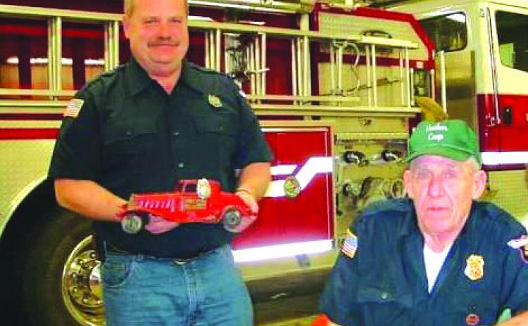 Al Willits (left) was chief at one time and presented this antique fire chief’s car to former chief Jim Lewis at Jim’s retirement party. Photo provided.