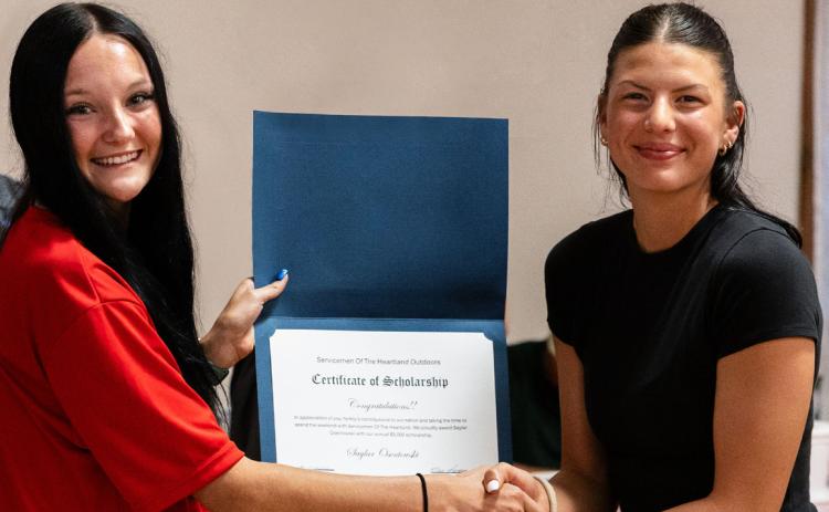 Saylar Osentowski (right), a 2023 Cross County graduate, received her $5000 Servicemen of the Heartland Outdoors scholarship to go to nursing school from the 2025 recipient. Osentowski currently attends Southeast Community College in Lincoln and will start nursing school at Union Adventist University in the fall. Photo by Danielle Treffer.