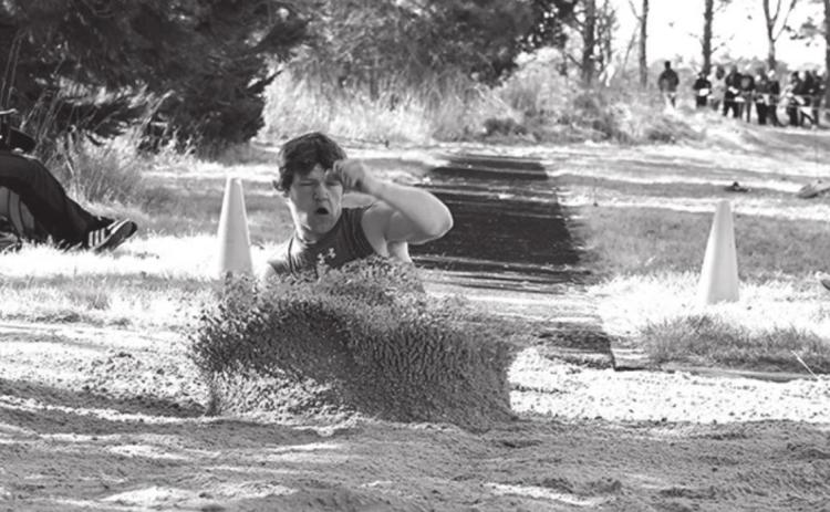 Trevor Carlstrom buries himself in the sand as he lands his triple jump for the Storm at the Osceola Invite.