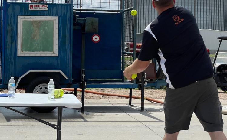 Above: Mark Gustafson throws a ball to try to dunk his son, Kale at the boys basketball dunk tank. Below: Peyton and Kendall Watts shoot water from a fire hose. PCN photos by Lexi Reimers.