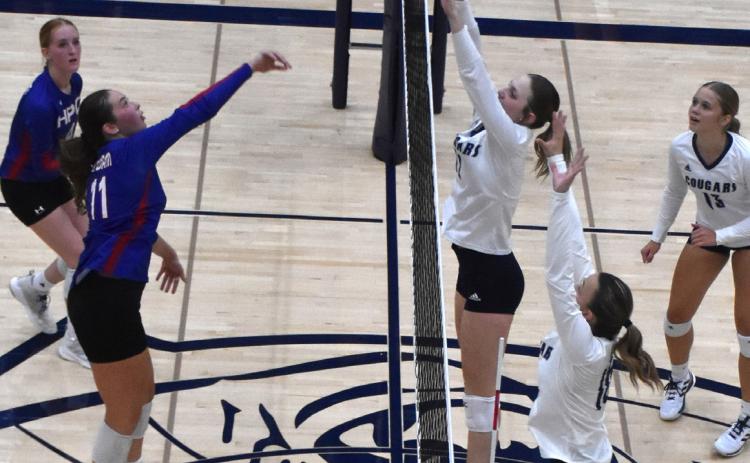 Rylee Ackerson tries to get a kill past the Cross County block of Bricelynn Larson. PCN photo by Beth Sparrow.