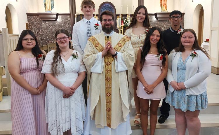 Seven graduating seniors were honored Sunday at Sacred Heart Catholic Church. Pictured are (front) Melanie Sanchez Diaz, Rebecca Wacker, Father Litt, Kendall Nickolite, Loralie Logan, (back) Kreyten Zimmerman, Elva Velasco and Joaquin Jaquez-Marquez. Photo provided