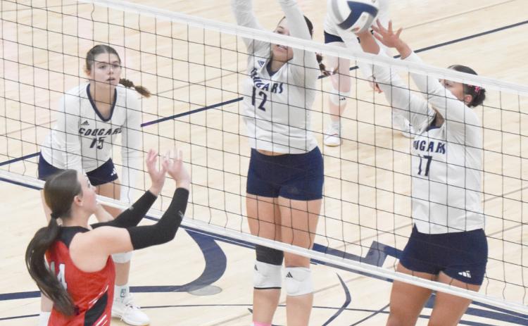 Cross County seniors Cortina Donnelly and Saphira Osentowski block the Meridian attack. PCN photo by Beth Sparrow.
