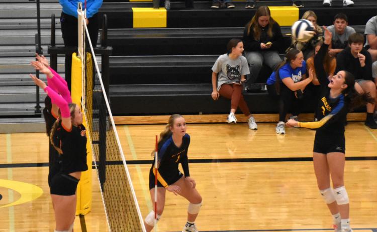 Kaleigh Ruth (left) goes up for the kill while Rori Wieseman and Taylin Sanley go up for the block. PCN photo by Beth Sparrow.