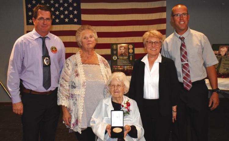 Spencer Tedford receives the Congressional Medal of Honor posthumously in Clarks on Tuesday. Receiving it for him was his wife, Ludmilla 'Millie' Tedford. Pictured left to right is Jason Morris, Sharon Russell, Mille, Barb Micek and Jarod Zoucha. PCN photo by Beth Sparrow.