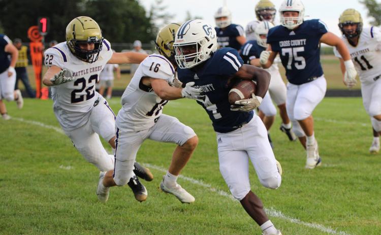 Cross County junior Tyion Francis (4) uses a stiff arm to keep the Battle Creek defender away in Friday nights game with Battle Creek won by the Cougars 35-14. PCN photo by Travis Lane.